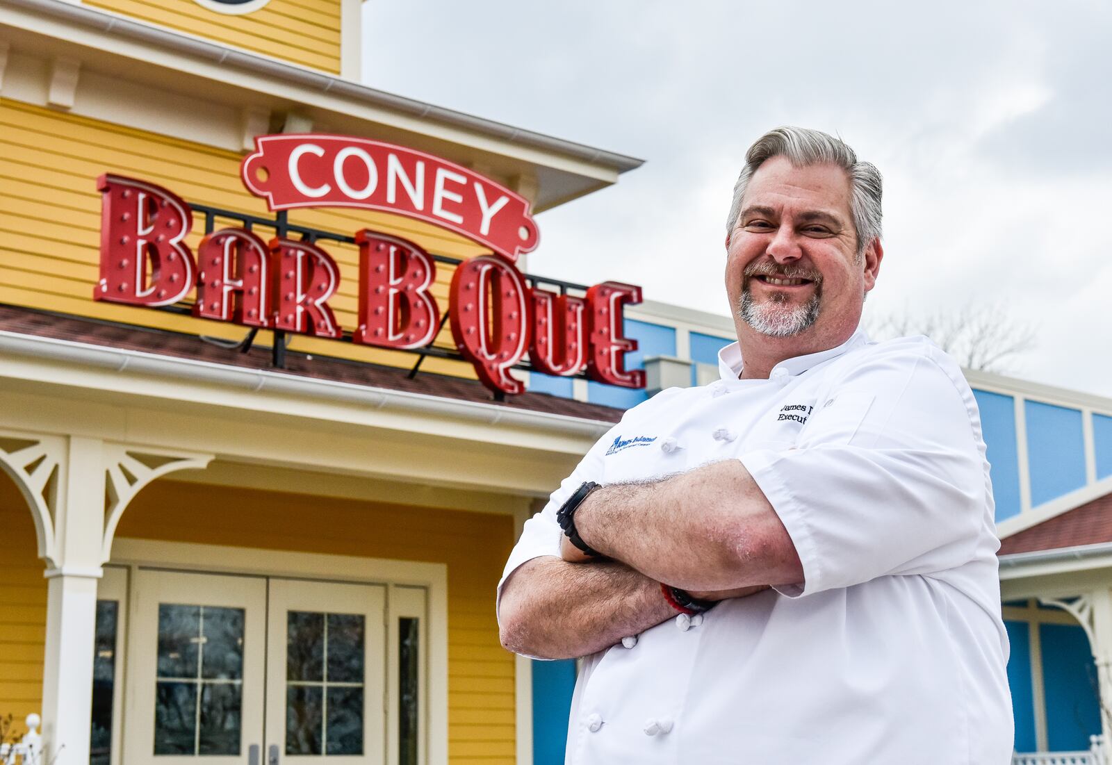 Kings Island Executive Chef James Major stand in front of the new Coney Bar B Que Tuesday, April 10 at the park in Mason. Kings Island held a preview event for the new restaurant and food items that will be available in the park this season. The new Coney Bar B Que will offer a variety of barbecue favorites including smoked St. Louis-style ribs, pulled pork, rotisserie chicken and Queen City Sausage. The new location is included in the park's dining plans. NICK GRAHAM/STAFF