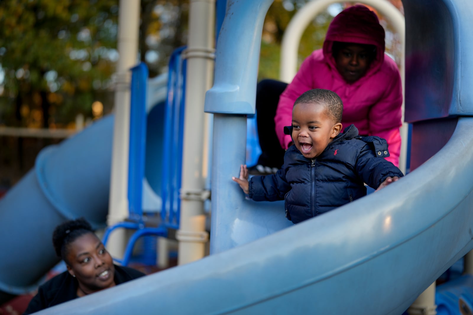 Anika Chillis, left, spends time with her children, Makhi, 2, center, and Myla 9, right, at a playground Monday, Dec. 2, 2024, in Memphis, Tenn. (AP Photo/George Walker IV)