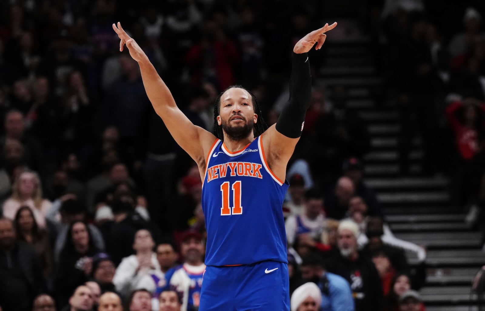 New York Knicks' Jalen Brunson (11) celebrates a 3-point basket against the Toronto Raptors during the second half of an NBA basketball game in Toronto on Tuesday, Feb. 4, 2025. (Nathan Denette/The Canadian Press via AP)