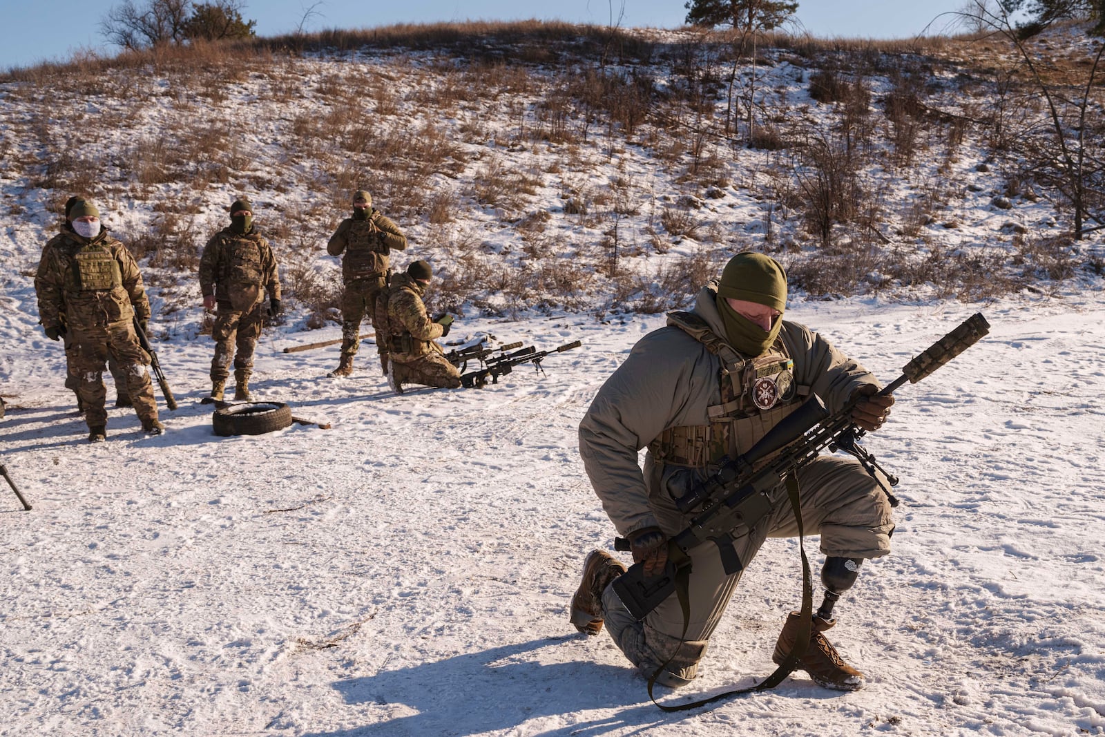 Serhii Pozniak, foreground, a sniper unit commander with the 27th national guard brigade who lost a leg after stepping on a mine, takes part in military training near Kyiv, Ukraine, on Feb. 17, 2025. (AP Photo/Evgeniy Maloletka)