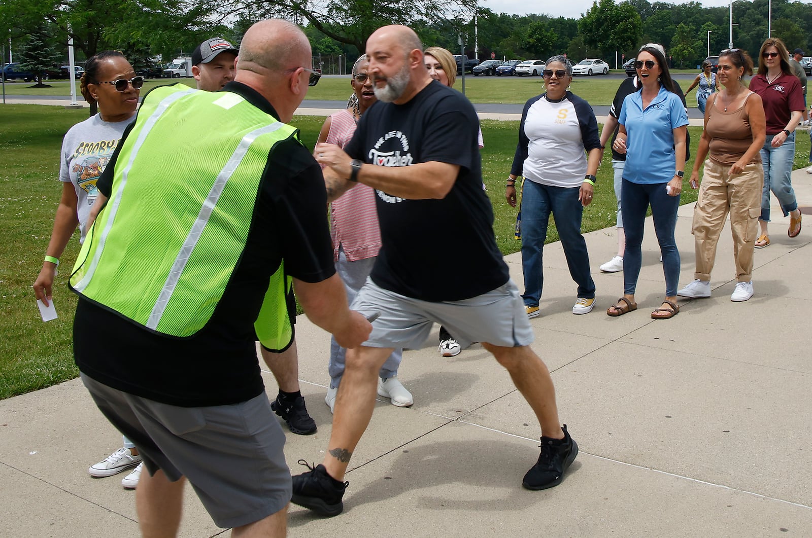 A man plays the part of an upset parent who refuses to wait for his child and rushes around staff to try and get into Springfield High School during a reunification training session Wednesday, June 5, 2024. Most of the Clark County schools along with law enforcement and fire personel participated in the two day training to learn how to get students back with their parents after an emergency situation. BILL LACKEY/STAFF