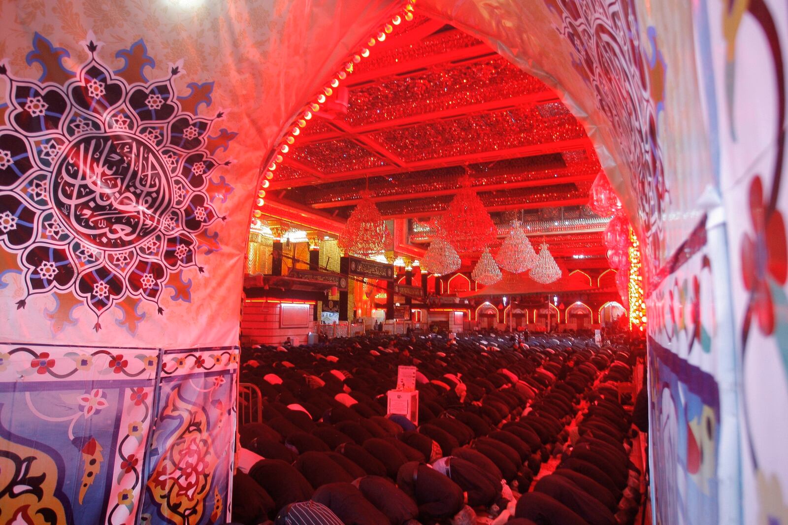 FILE - In this Sept. 10, 2019, file photo, Shiite Muslim worshippers pray inside the shrine of Imam Abbas on the holy day of Ashoura, in Karbala, Iraq. Shiites mark Ashoura, the 10th day of the month of Muharram, to commemorate the Battle of Karbala, in which Imam Hussein, a grandson of Prophet Muhammad, was killed.  Ordinarily Ashoura is marked with public celebrations around the world. But with the pandemic sweeping the globe and cases rising in Iraq, the country's top Shiite cleric, Grand Ayatollah Ali al-Sistani, encouraged people to observe the day in other ways such as watching online or televised commemorations from home. (AP Photo/Anmar Khalil, File)