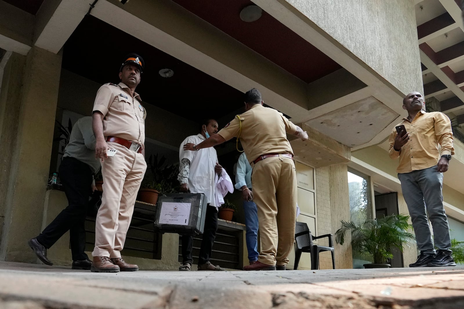 Police and forensic officials outside Bollywood actor Saif Ali Khan's residential building after he was operated for stab injuries following a scuffle with an intruder at his home in Mumbai, Thursday, Jan. 16, 2025.(AP Photo/Rajanish Kakade)