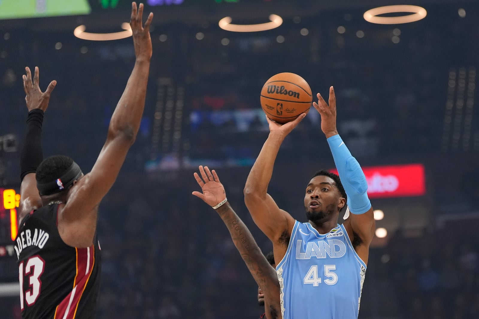 Cleveland Cavaliers guard Donovan Mitchell (45) shoots in front of Miami Heat center Bam Adebayo (13 in the first half of an NBA basketball game Wednesday, March 5, 2025, in Cleveland. (AP Photo/Sue Ogrocki)