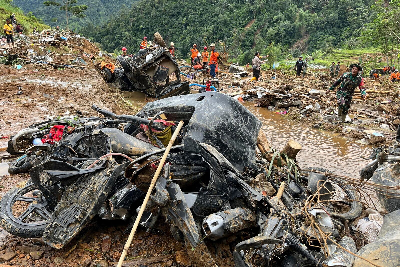 Rescuers search for victims near the wreckages of vehicles in an area affected by a landslide following a flash flood that killed multiple people in Pekalongan, Central Java, Indonesia, Thursday, Jan. 23, 2025. (AP Photo/Janaki DM)