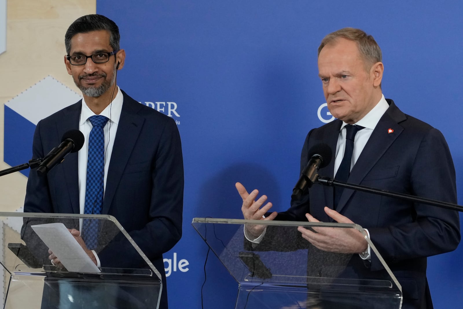 Google and Alphabet CEO Sundar Pichai, left, and Poland's Prime Minister Donald Tusk, right, announce they have signed a memorandum for developing the use of artificial intelligence in the energy and cybersecurity sectors and other fields in Poland, at the Google Startup Campus in Warsaw, Poland, on Thursday, Feb. 13, 2025. (AP Photo/Czarek Sokolowski)