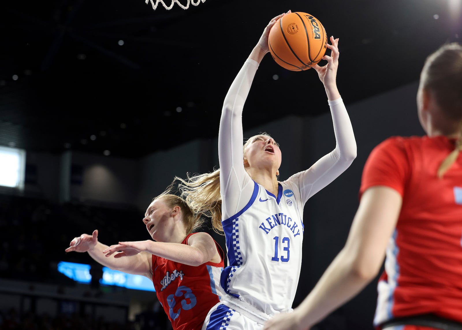 Kentucky's Clara Strack (13) pulls down a rebound over Liberty's Emma Hess, left, during the first half in the first round of the NCAA college basketball tournament in Lexington, Ky., Friday, March 21, 2025. (AP Photo/James Crisp)