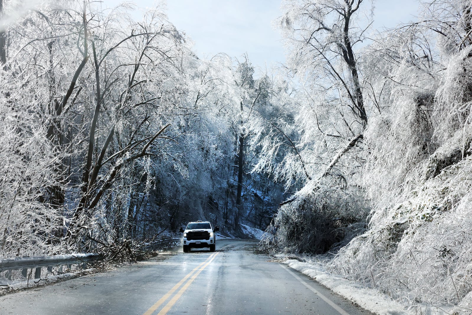 A motorist navigates drooping branches on Merriman Road in Franklin County after a winter storm affected the area Thursday, Feb. 13, 2025, in Franklin County, Va. (Heather Rousseau/The Roanoke Times via AP)