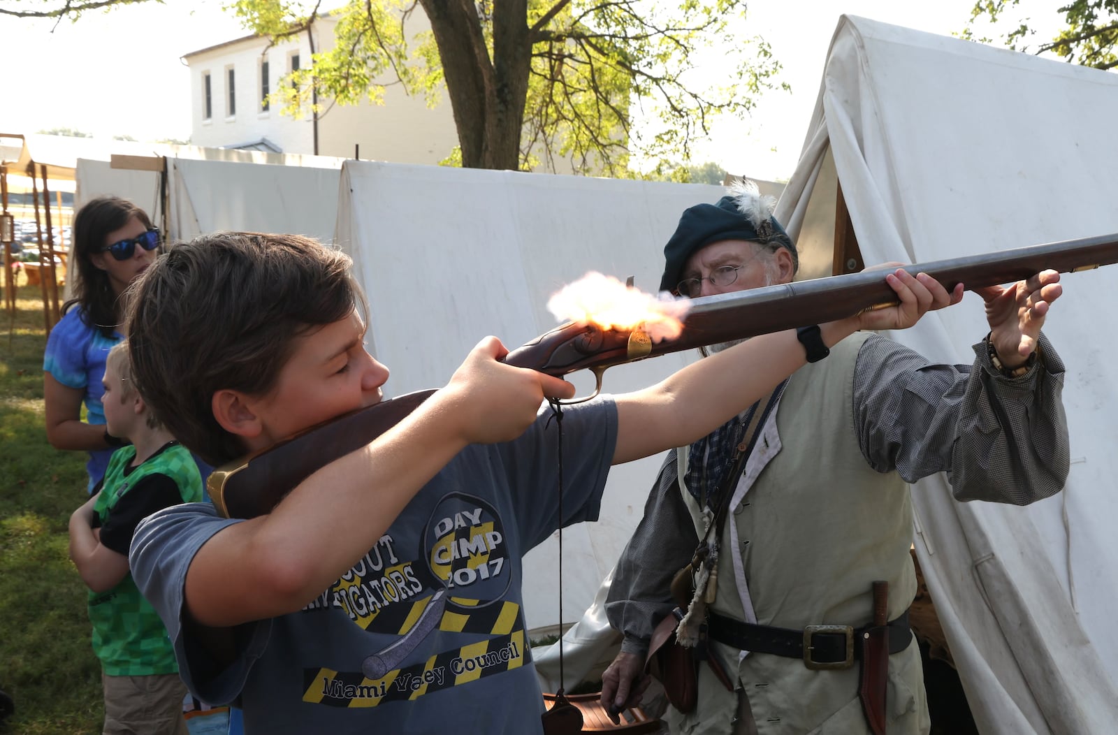 Fair at New Boston reenactor Rob Kahn helps Gabe Simons, 13, fire his flintlock on Friday, Aug. 30, 2024, during education day at The Fair at New Boston, just outside Springfield. BILL LACKEY / STAFF