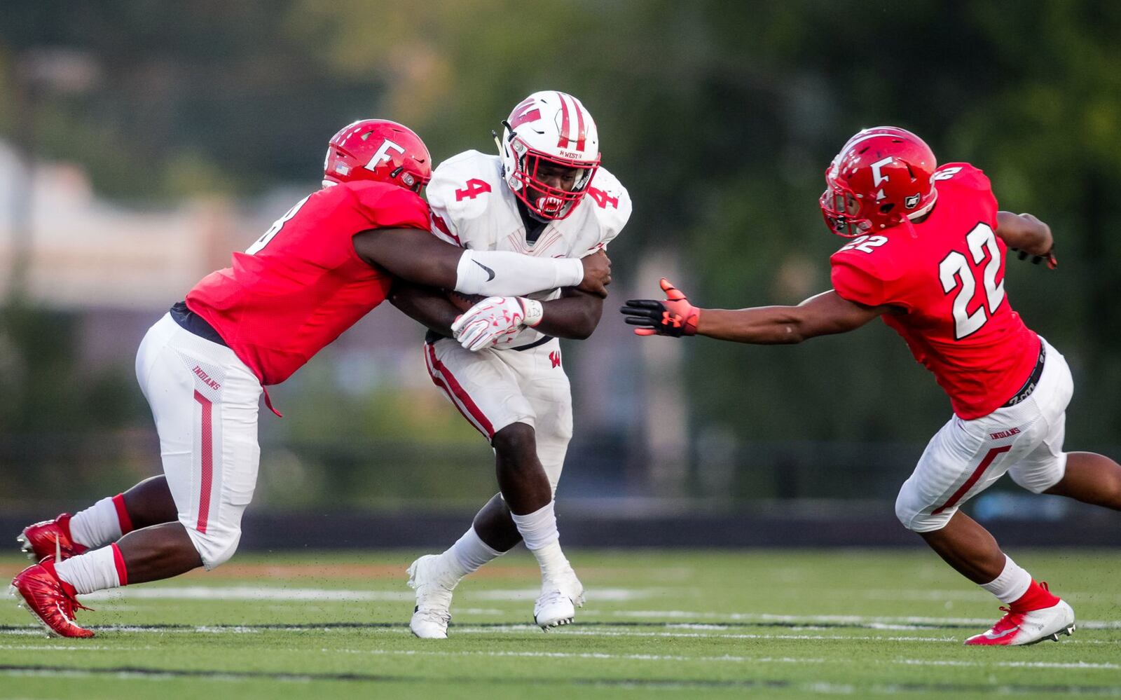 Lakota West’s David Afari carries the ball and is surrounded by Fairfield’s Greg Fitzpatrick (left) and Dealo McIntosh during Sept. 14 game at Fairfield Stadium. Fairfield won 37-3. NICK GRAHAM/STAFF