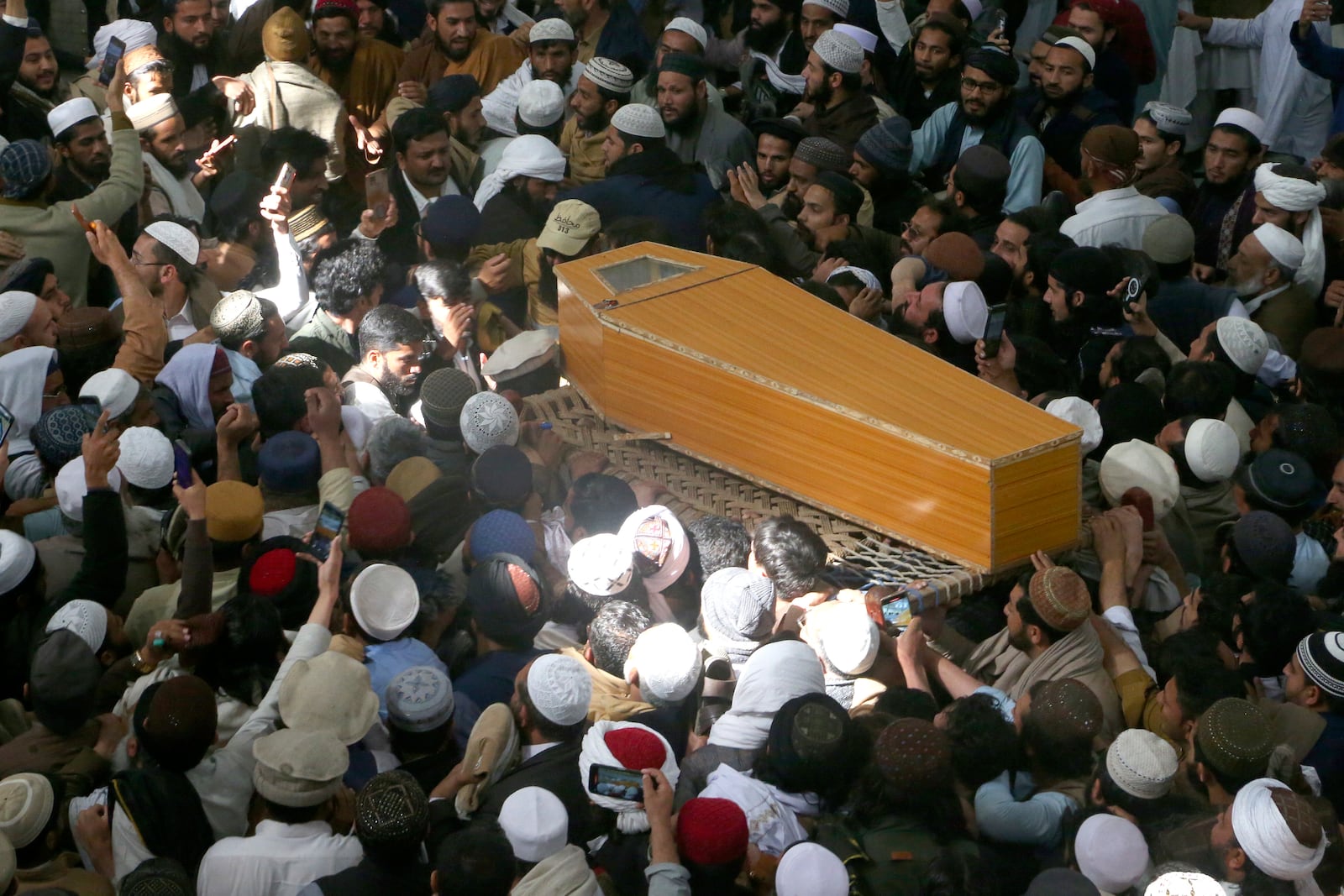 Mourners carry the casket of a senior Muslim cleric, Hamidul Haq who was killed in the Friday's suicide bomb attack at a pro-Taliban seminary, during a funeral prayer in Akora Khattak, Pakistan, Saturday, March 1, 2025. (AP Photo/Muhammad Sajjad)