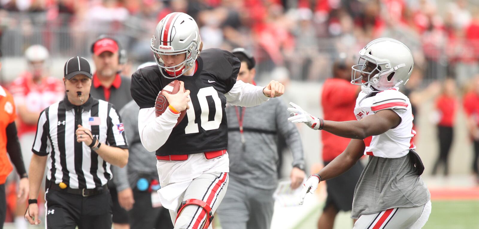 Ohio State’s Joe Burrow, left, is pushed out of bounds during the spring game on Saturday, April 14, 2018, at Ohio Stadium in Columbus. David Jablonski/Staff