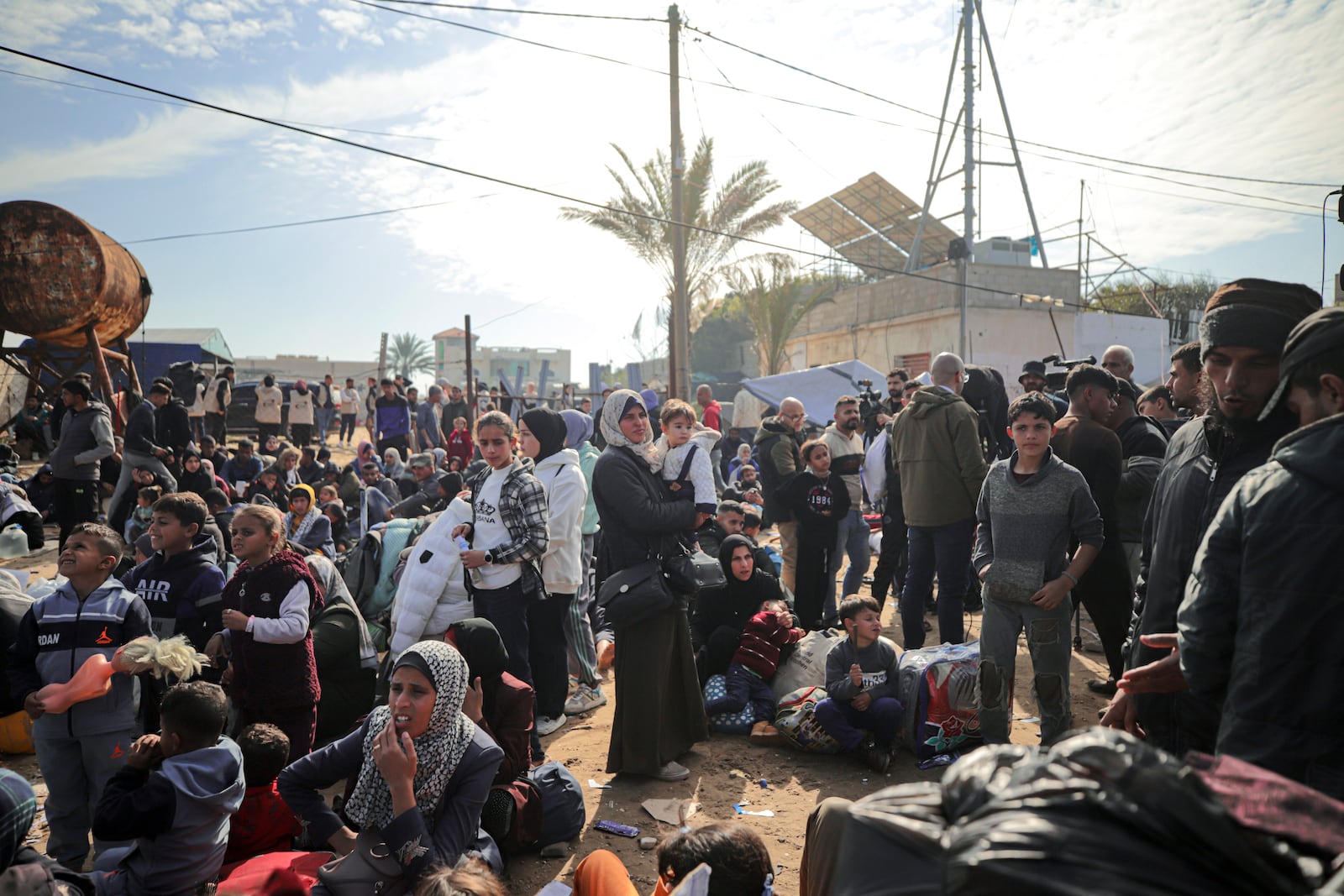 Displaced Palestinians gather with their belongings near a roadblock on the al Rashid Street, as they wait to return to their homes in the northern part of the Gaza Strip, Sunday, Jan. 26, 2025, days after the ceasefire deal between Israel and Hamas came into effect. (AP Photo/ Jehad Alshrafi)