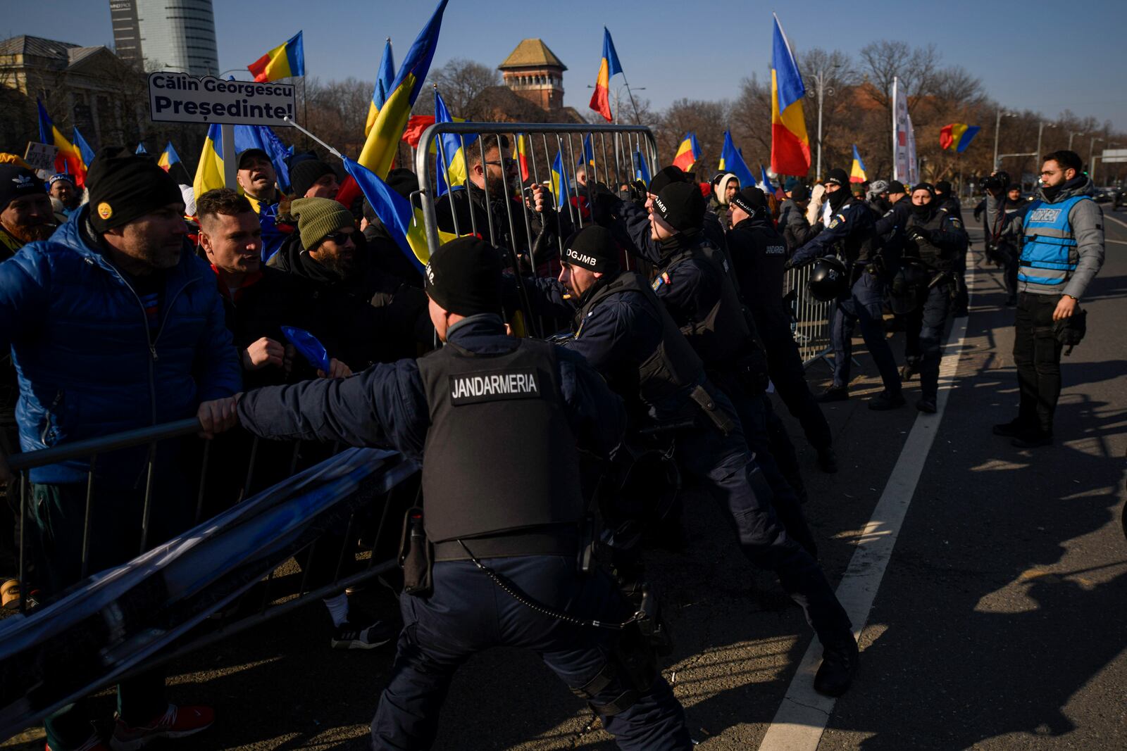 Riot police scuffle with supporters of Calin Georgescu, the winner of Romania's first round of presidential election which the Constitutional Court later annulled, who broke through police lines in front of the government headquarters, in Bucharest, Romania, Monday, Feb. 10, 2025. (AP Photo/Alexandru Dobre)