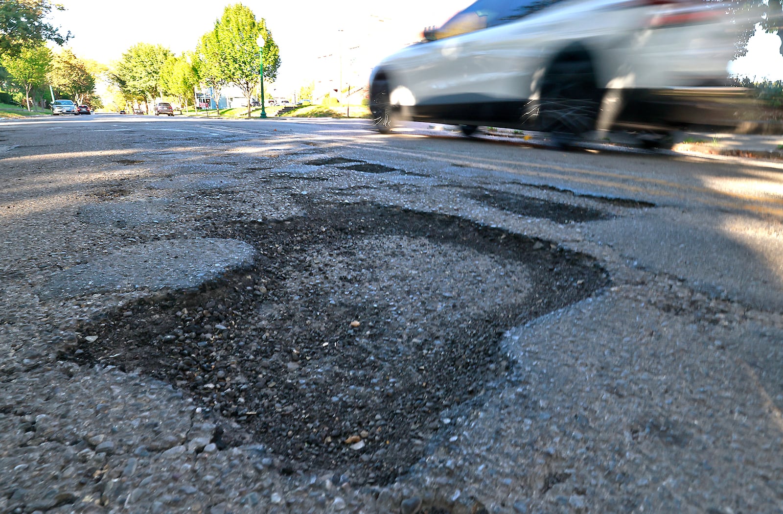 A car zips past a large pothole on South Limestone Street on Tuesday, Oct. 9, 2024. BILL LACKEY/STAFF