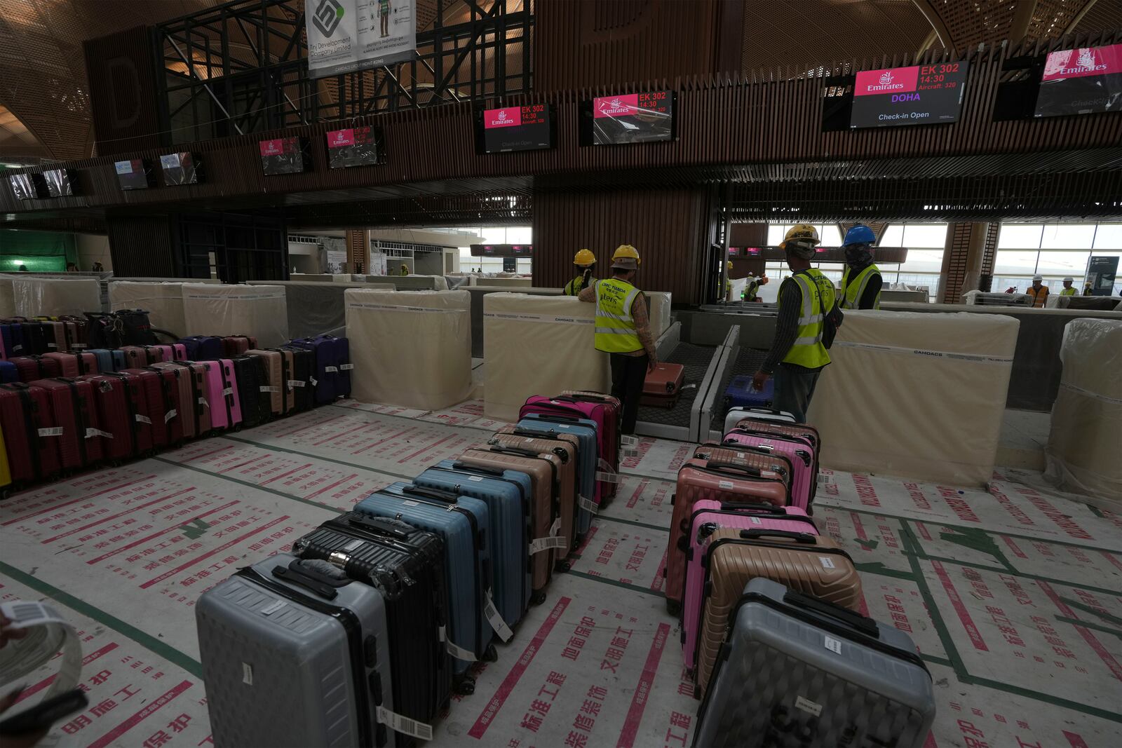 Airport staff members test the luggage machine inside an under construction of a new airport of Techo International Airport at the outskirts of Phnom Penh Cambodia, Friday, March 21, 2025. (AP Photo/Heng Sinith)