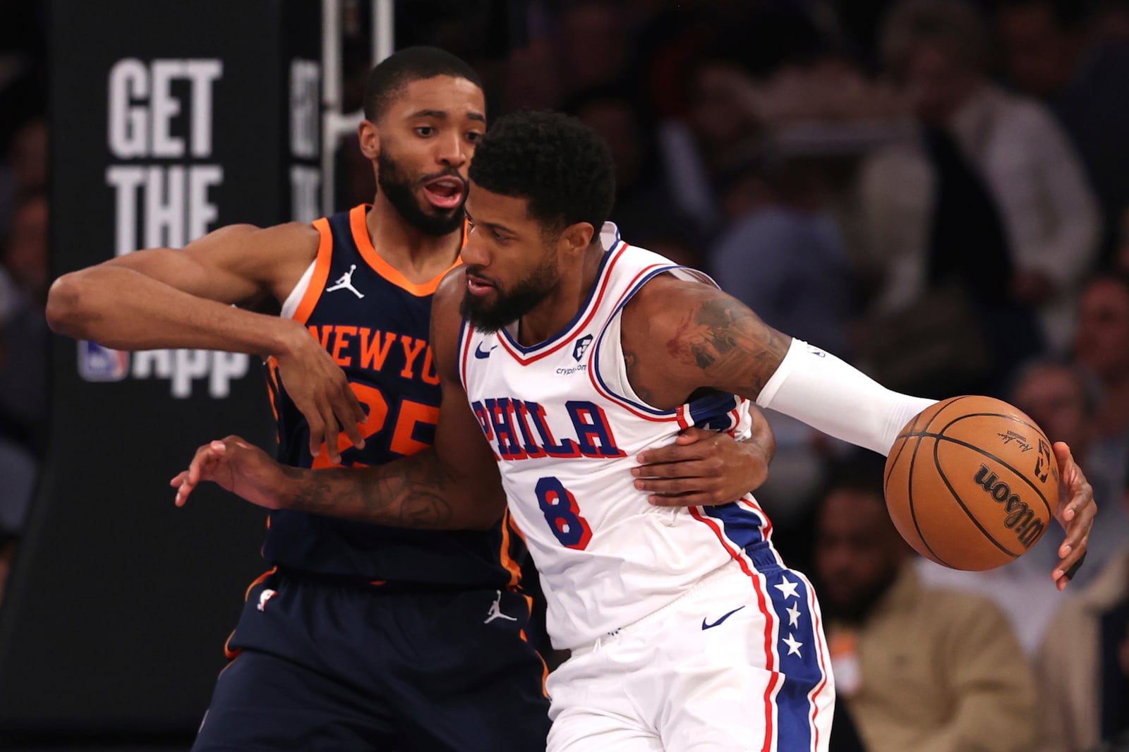 Philadelphia 76ers' Paul George, right, dribbles the ball against New York Knicks' Mikal Bridges during the first half of an NBA basketball game, Wednesday, Feb. 26, 2025, in New York. (AP Photo/Pamela Smith)