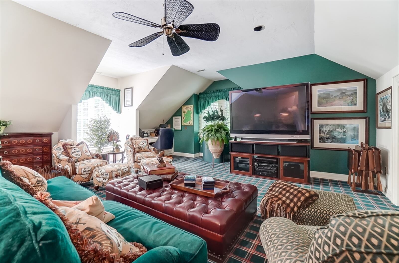 A back staircase leads directly into the second-floor recreation room. Two large dormer window nooks provide extra seating, and there is a built-in desk within another nook. 