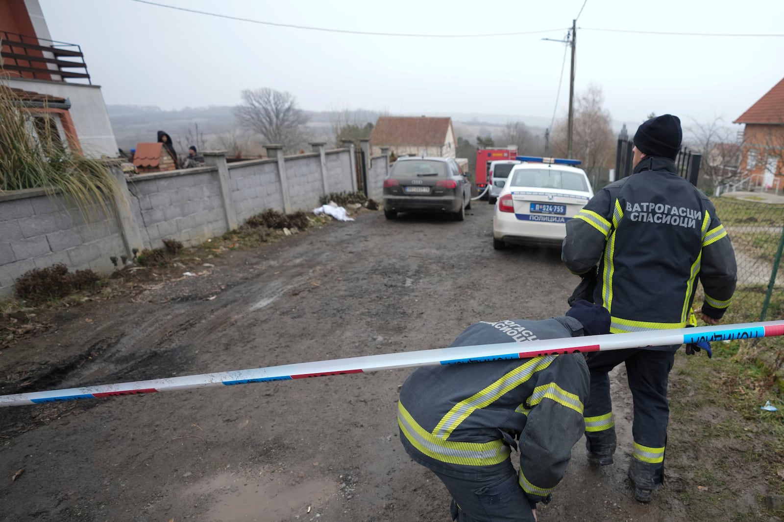 Firefighters walk in front of a home for the elderly where eight people died in a fire, in Barajevo, a municipality of Belgrade, Serbia, Monday, Jan. 20, 2025. (AP Photo/Darko Vojinovic)