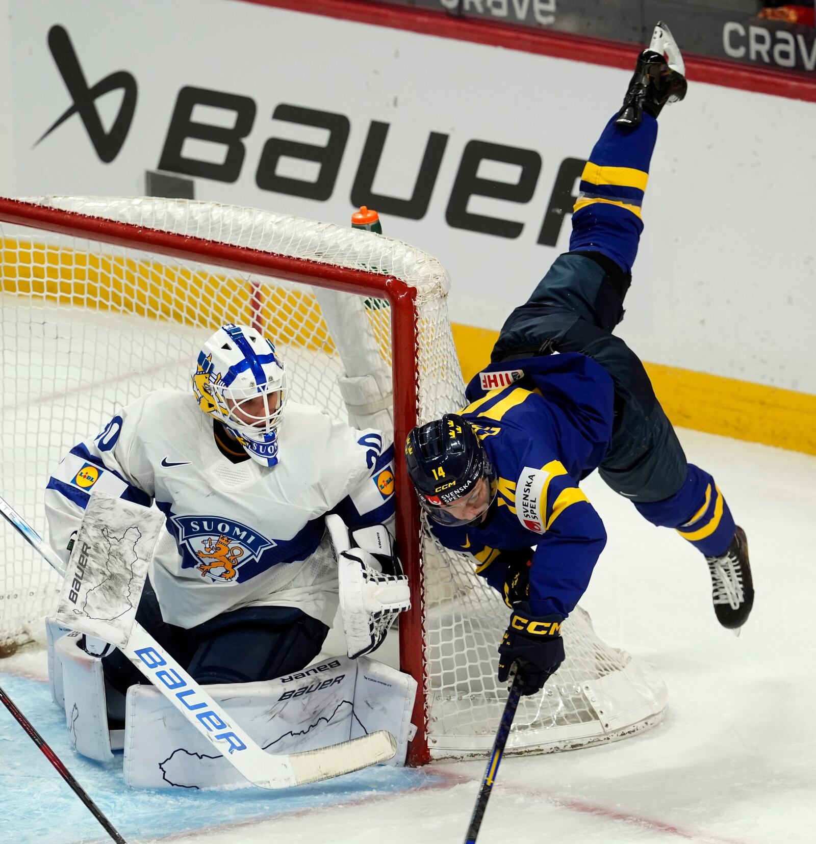 Finland goaltender Petteri Rimpinen looks on as Sweden forward Linus Eriksson flies through the air after clipping the net during the first period of a semifinal game at the world junior hockey championship, Saturday, Jan. 4, 2025 in Ottawa, Ontario. (Adrian Wyld/The Canadian Press via AP)