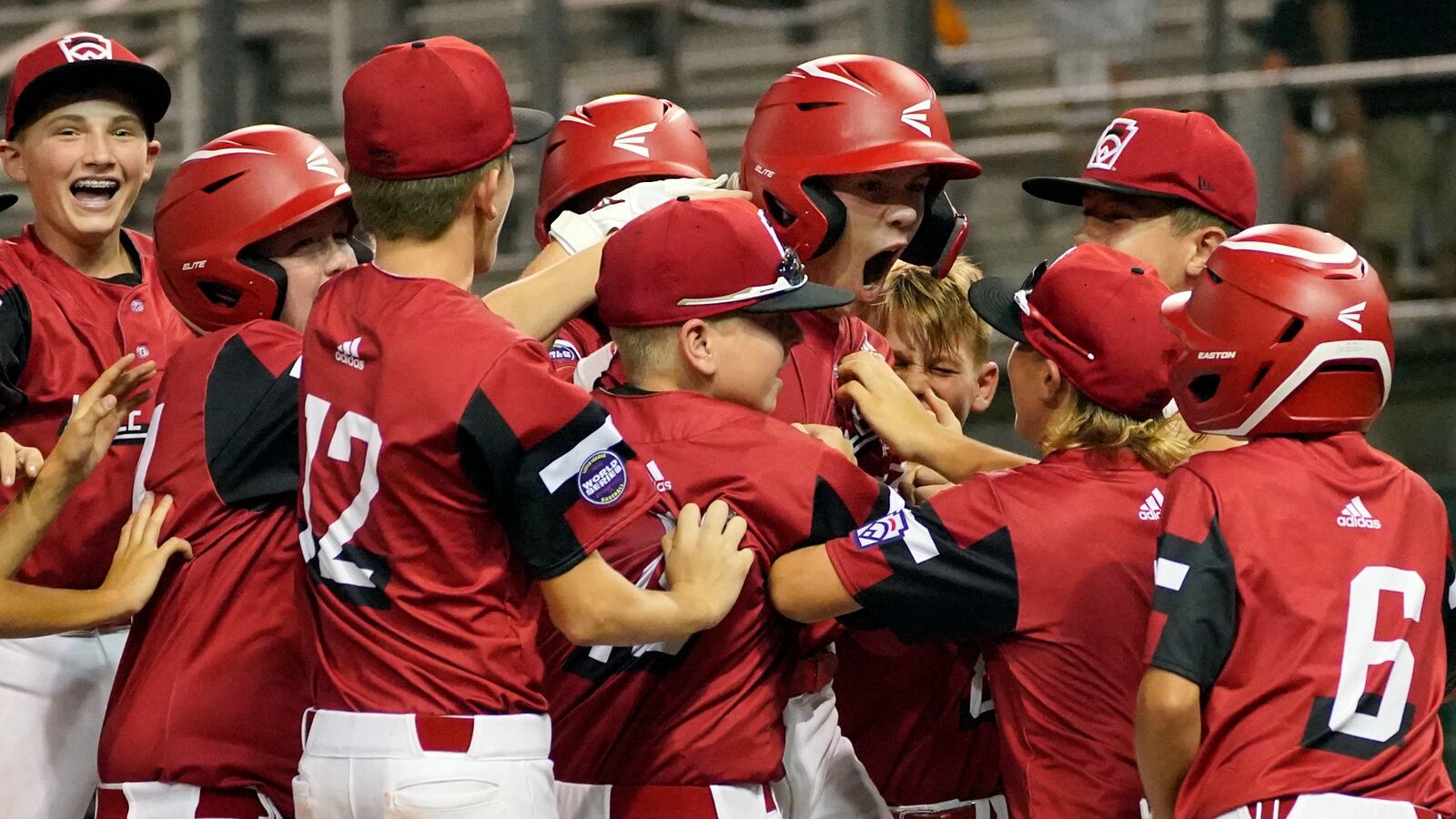 Hamilton, Ohio's JJ Vogel, center, is mobbed by teammates as they celebrate after his three-run home run off Lafayette, La., pitcher Landon Granger during a baseball game at the Little League World Series tournament in South Williamsport, Pa., Monday, Aug. 23, 2021. (AP Photo/Tom E. Puskar)