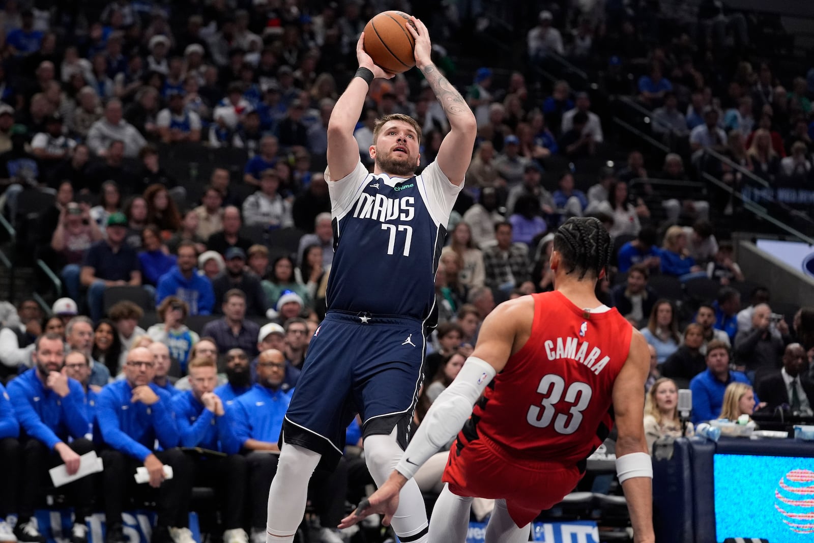 Dallas Mavericks guard Luka Doncic (77) shoots against Portland Trail Blazers forward Toumani Camara (33) during the second half of an NBA basketball game, Monday, Dec. 23, 2024, in Dallas. (AP Photo/LM Otero)