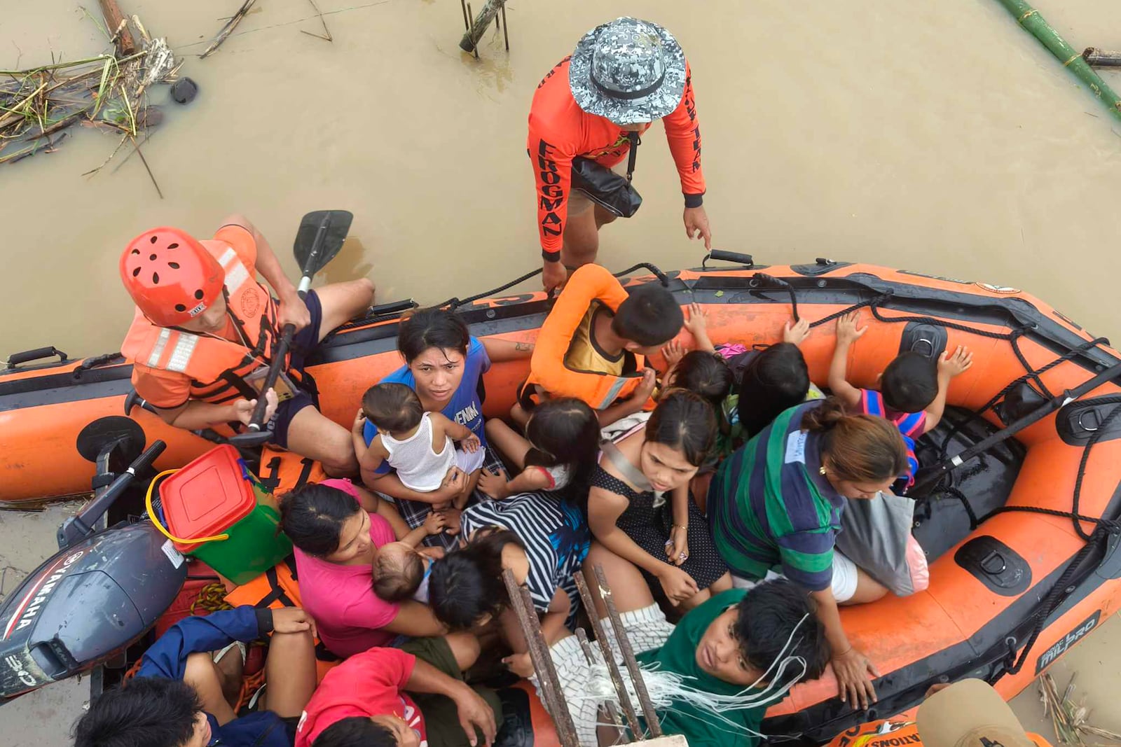 Residents are ferried on a rubber boat after being rescued from their roofs where they stayed to avoid high floods caused by Tropical Storm Trami hit Libon town, Albay province, Philippines on Wednesday Oct. 23, 2024. (Michelle Ricasio via AP)