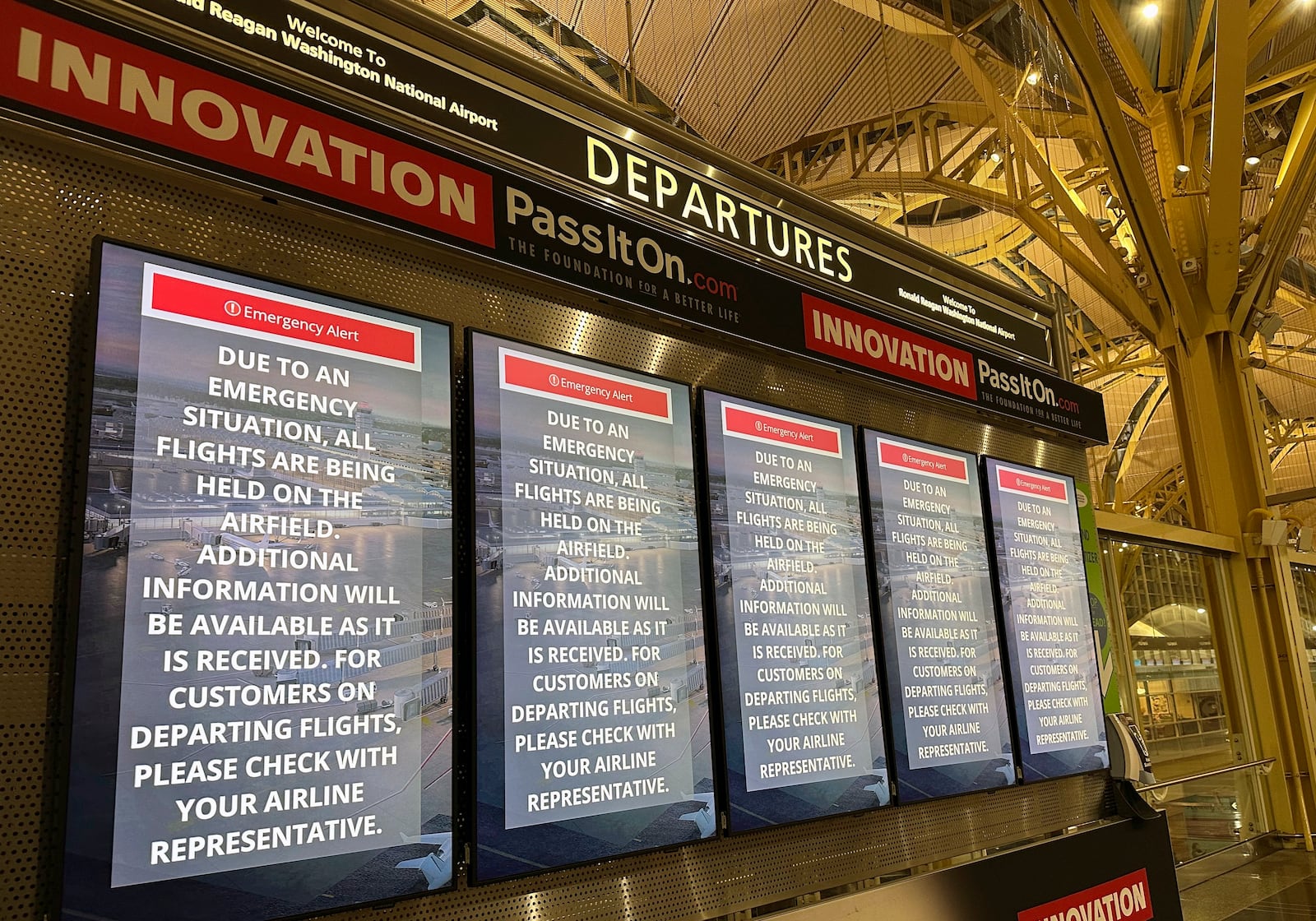 Departure signs display an "Emergency Alert" in the terminal at Ronald Reagan Washington National Airport, Wednesday night, Jan. 29, 2025, in Arlington, Va. A jet with 60 passengers and four crew members aboard collided with an Army helicopter while landing at Ronald Reagan National Airport near Washington, prompting a large search-and-rescue operation in the nearby Potomac River. (AP Photo/Jeannie Ohm)