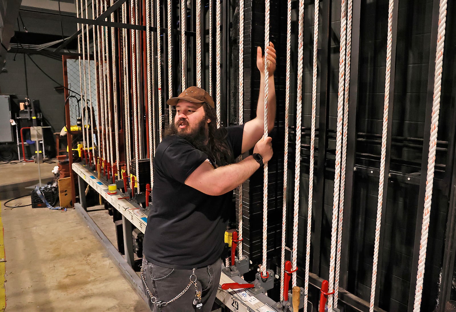 Charles Mitchell lowers a light into place back stage at Kuss Auditorium Thursday, March 16, 2023 as he and other stage personnel get ready for a show by Sheena Easton later that evening in Springfield. BILL LACKEY/STAFF