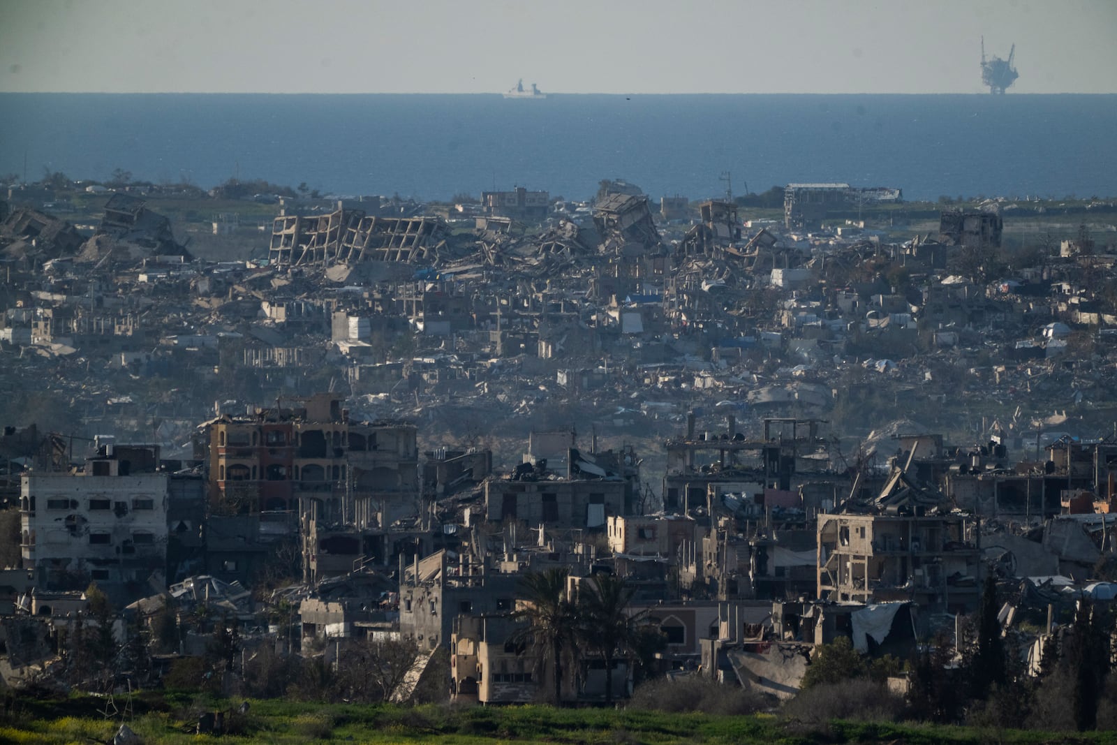 Buildings destroyed during the Israeli air and ground offensive stand in the Gaza Strip are seen from southern Israel, Sunday, March 2, 2025. (AP Photo/Leo Correa)