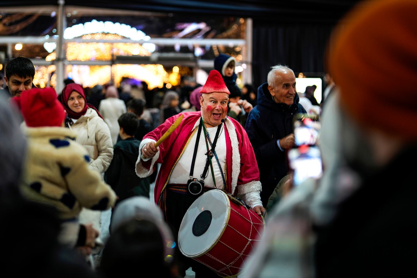 A man in a clown costume performs in a square on the first day of the Muslim holy month of Ramadan in Istanbul, Turkey, Saturday, March 1, 2025. (AP Photo/Khalil Hamra)