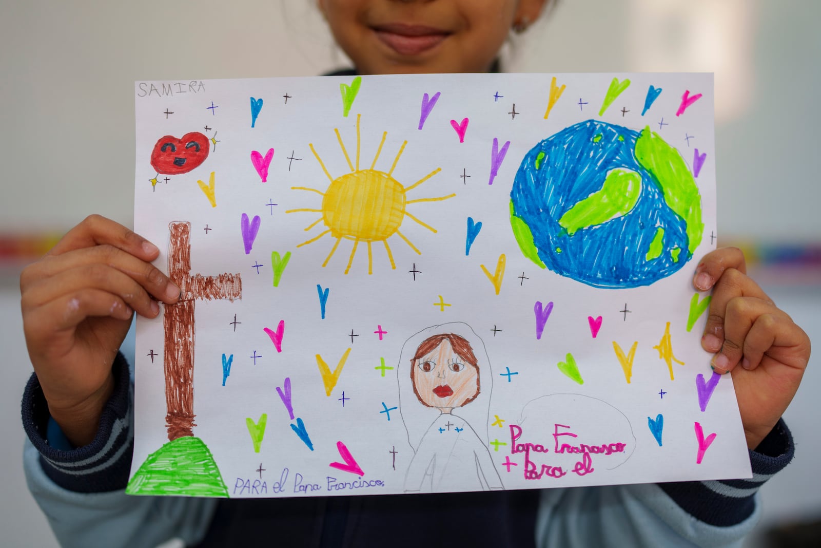 Samira, 8, shows s a picture reading in Spanish: "For the Pope Francisco" as part of an initiative to encourage Pope Francisco in his recovery, with the drawings to be sent to him as a sign of affection at Beata Maria Jesus School in Madrid, Spain, on Friday, Feb. 21, 2025. (AP Photo/Manu Fernandez)