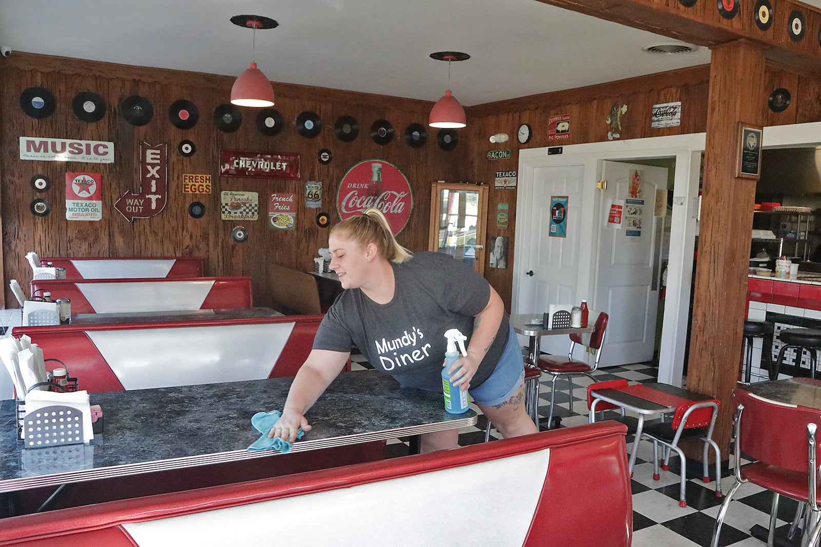 Sierra Knapp, an employee of Mundy's Diner, cleans off a table after the breakfast rush Wednesday, August 31, 2022. BILL LACKEY/STAFF