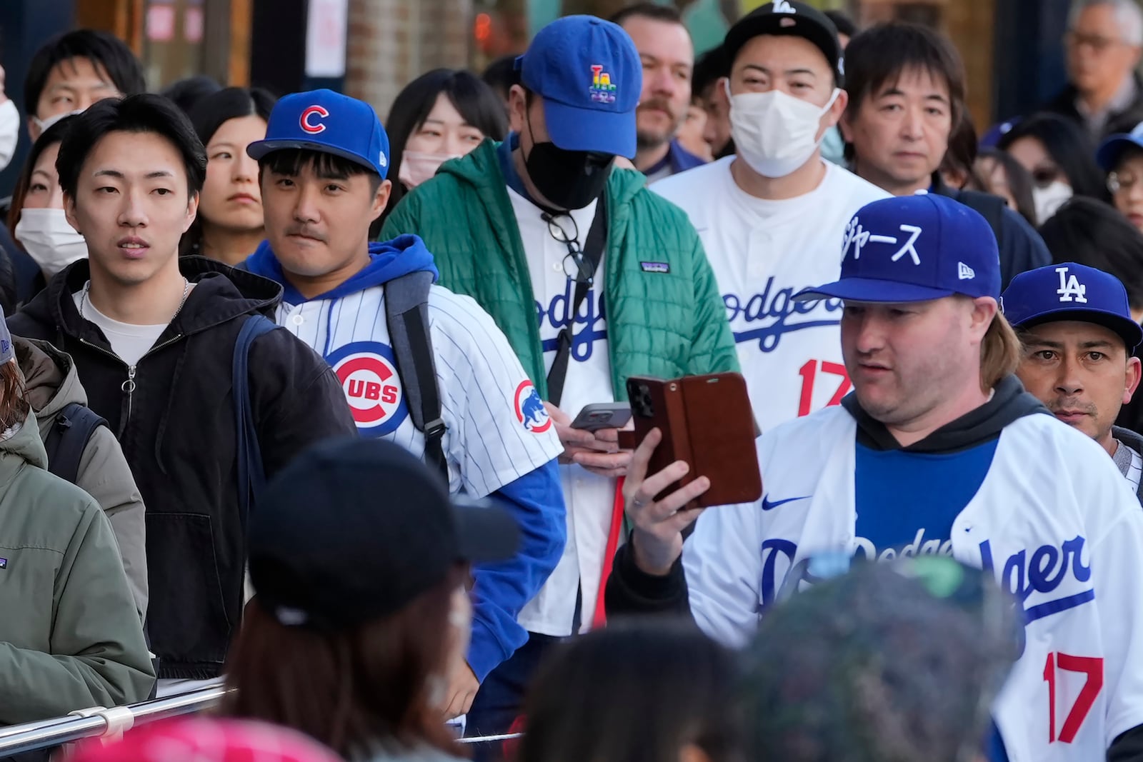 Fans of the Chicago Cubs and the Los Angeles Dodgers walk around the Tokyo Dome ahed of an MLB Tokyo Series baseball game between the Los Angeles Dodgers and the Chicago Cubs, in Tokyo, Tuesday, March 18, 2025. (AP Photo/Shuji Kajiyama)