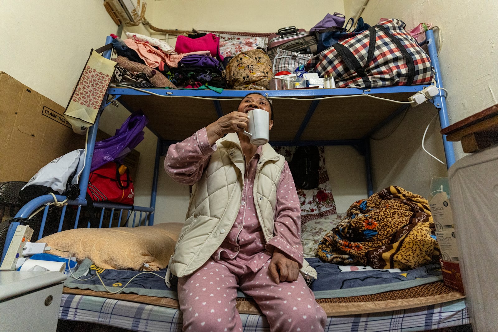 Resident Tsang Mei Qin sits at her subdivided flat in Sham Shui Po district of Hong Kong, on Feb. 6, 2025. (AP Photo/Chan Long Hei)