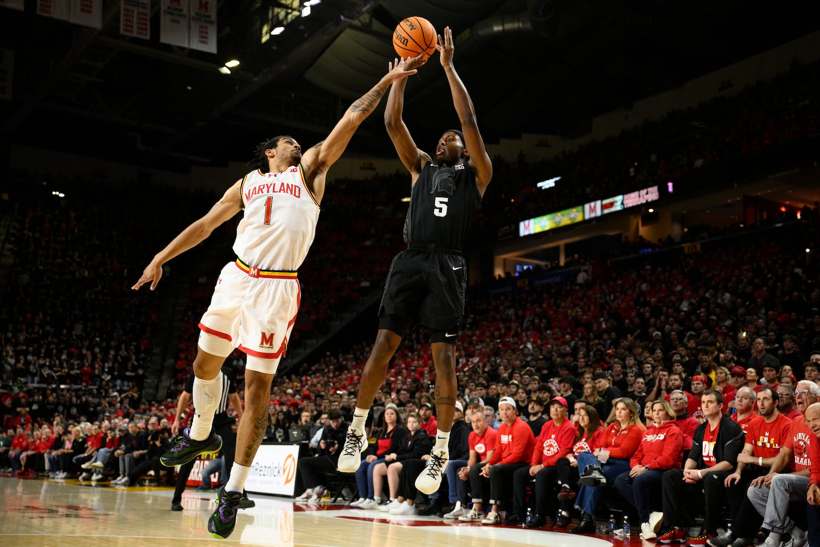 Michigan State guard Tre Holloman (5) shoots against Maryland guard Rodney Rice (1) during the first half of an NCAA college basketball game, Wednesday, Feb. 26, 2025, in College Park, Md. (AP Photo/Nick Wass)