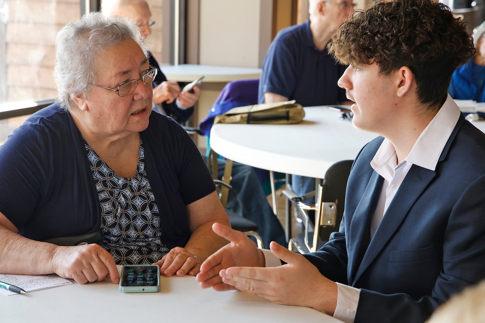 Mark Koyl, a junior from the Springfield/Clark CTC, helps Betty Jane Gardner, a resident of the Springfield Masonic Community, with her phone Friday, Feb. 23, 2024. Mark and several other Cyber Security students from CTC were at the Masonic Community to help the seniors with technology. BILL LACKEY/STAFF