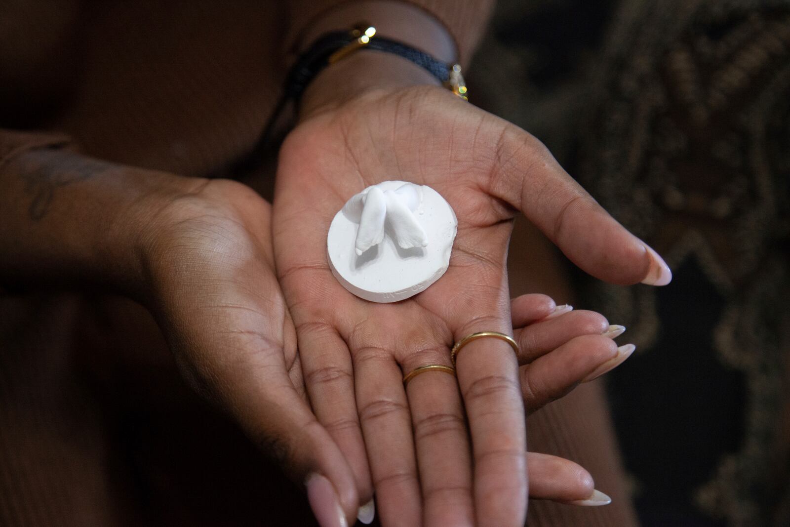 Doneysha Smith shows a miniature plaster sculpture of the feet of her 18-week-old baby Lux Siloam at her home in Sherwood, Arkansas, Tuesday, Feb. 11, 2025. After being stillborn at 18 weeks, Lux's body was stolen and sold to traffickers in two states, prompting an FBI investigation. A proposed law, known as Lux's Law, would prohibit the sale of dead bodies that were intended to be cremated or buried and establish penalties in Arkansas. (AP Photo/Katie Adkins)