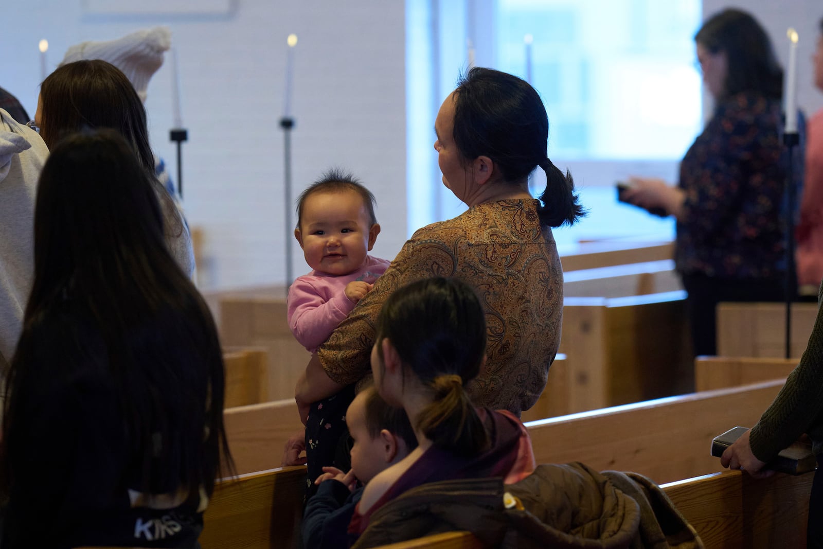 A baby is held by her mother as they attend a religious service at Hans Egede Church in Nuuk, Greenland, Sunday, Feb. 16, 2025. (AP Photo/Emilio Morenatti)