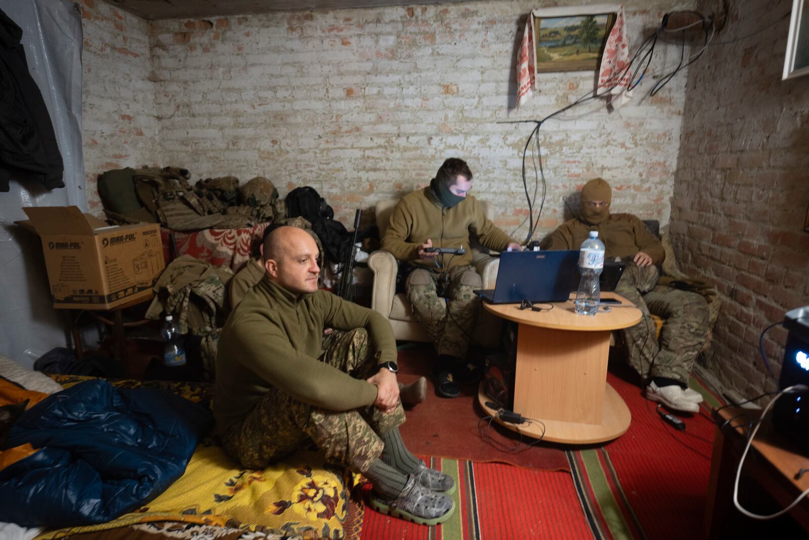 Ukraine's Khartia brigade officer, who goes by callsign Kit, left, sits while his soldiers pilot drones in a shelter on the frontline near Kharkiv, Ukraine, late Thursday, Nov. 7, 2024. (AP Photo/Efrem Lukatsky)