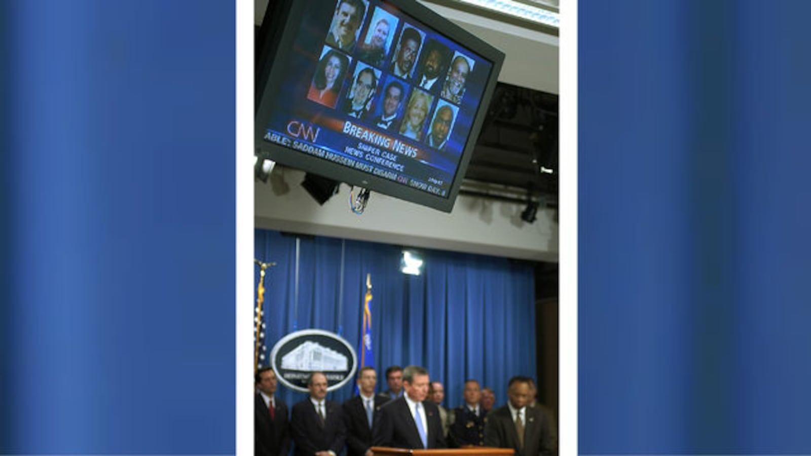 Photos of the 10 Washington, D.C.-area victims of Beltway snipers John Allen Muhammad and Lee Boyd Malvo are seen on a TV screen during a November 2002 news conference led by then-U.S. Attorney General John Ashcroft.