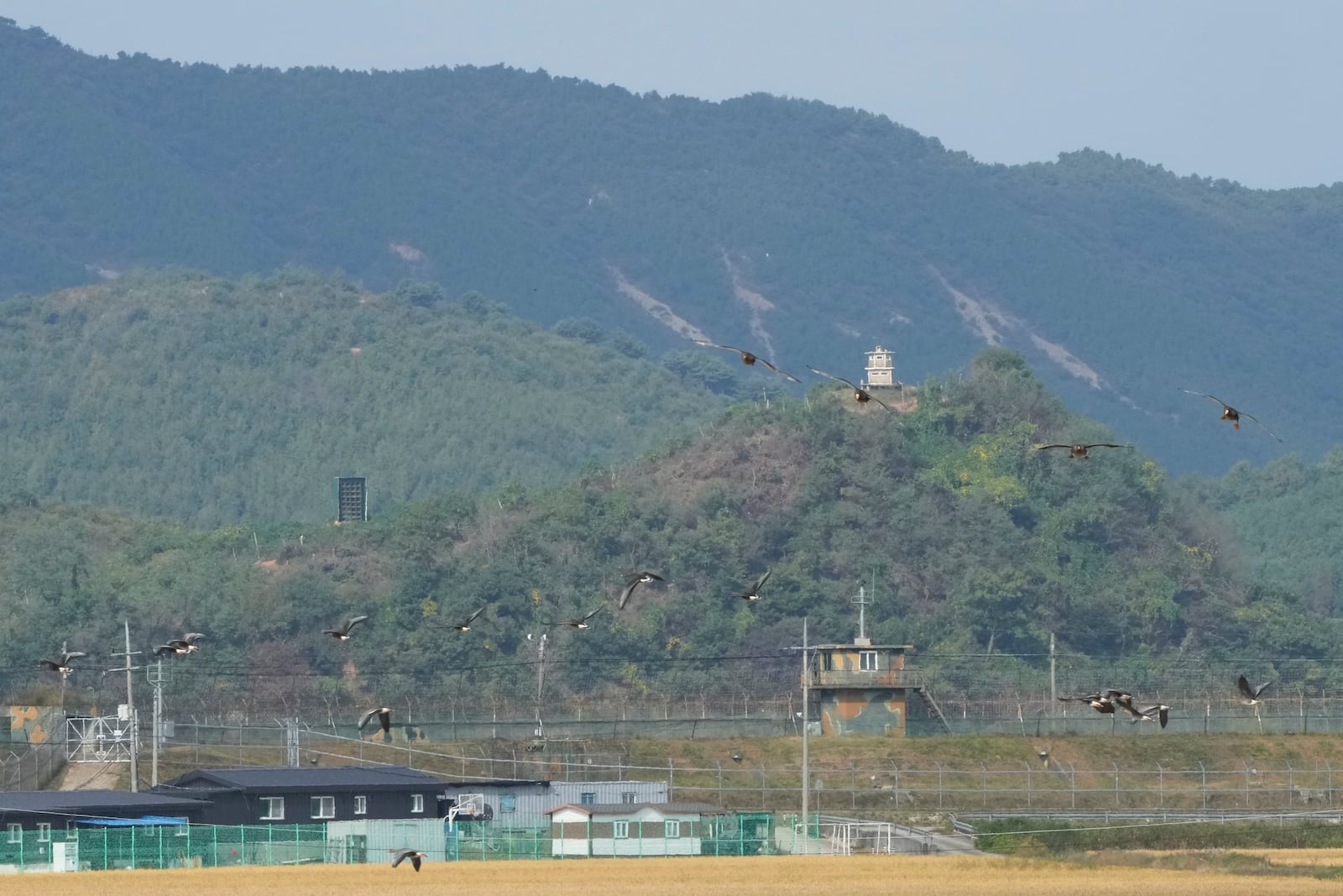 A North Korean loudspeaker, top left, a military guard post, top right, and a South Korean military guard post, bottom, are seen from Paju, South Korea, near the border with North Korea, Thursday, Oct. 10, 2024. (AP Photo/Ahn Young-joon)