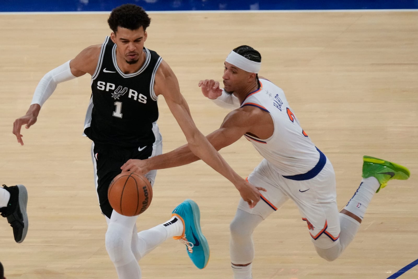 New York Knicks' Josh Hart, right, tries to grab the ball from San Antonio Spurs' Victor Wembanyama during the second half of an NBA basketball game, Wednesday, Dec. 25, 2024, in New York. The Knicks defeated the Spurs 117-114. (AP Photo/Seth Wenig)