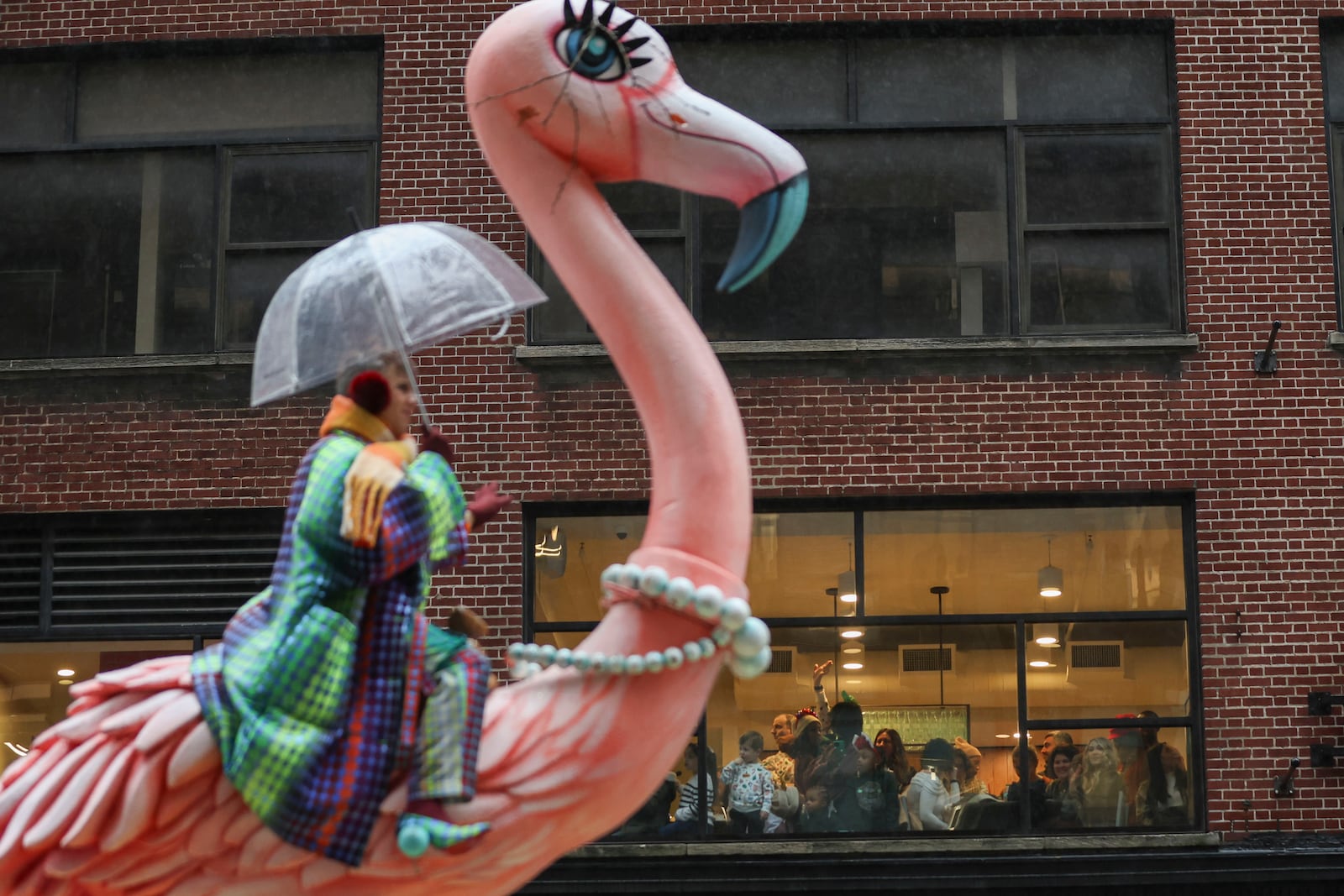 People watch from inside as the Macy's Thanksgiving Day parade goes by, Thursday, Nov. 28, 2024, in New York. (AP Photo/Heather Khalifa)