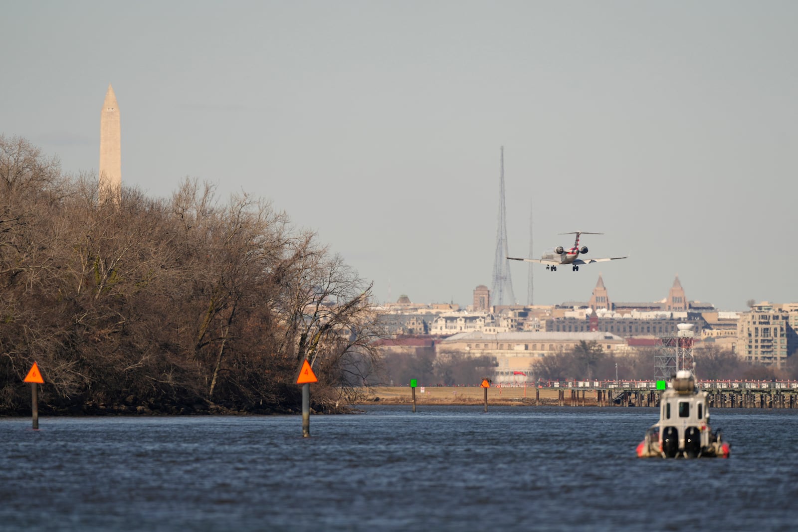 An American Airlines jet approaches Ronald Reagan Washington National Airport Saturday, Feb. 1, 2025, in Alexandria, Va., near the wreckage site in the Potomac river where an American Airlines jet and a Black Hawk helicopter collided. (AP Photo/Carolyn Kaster)