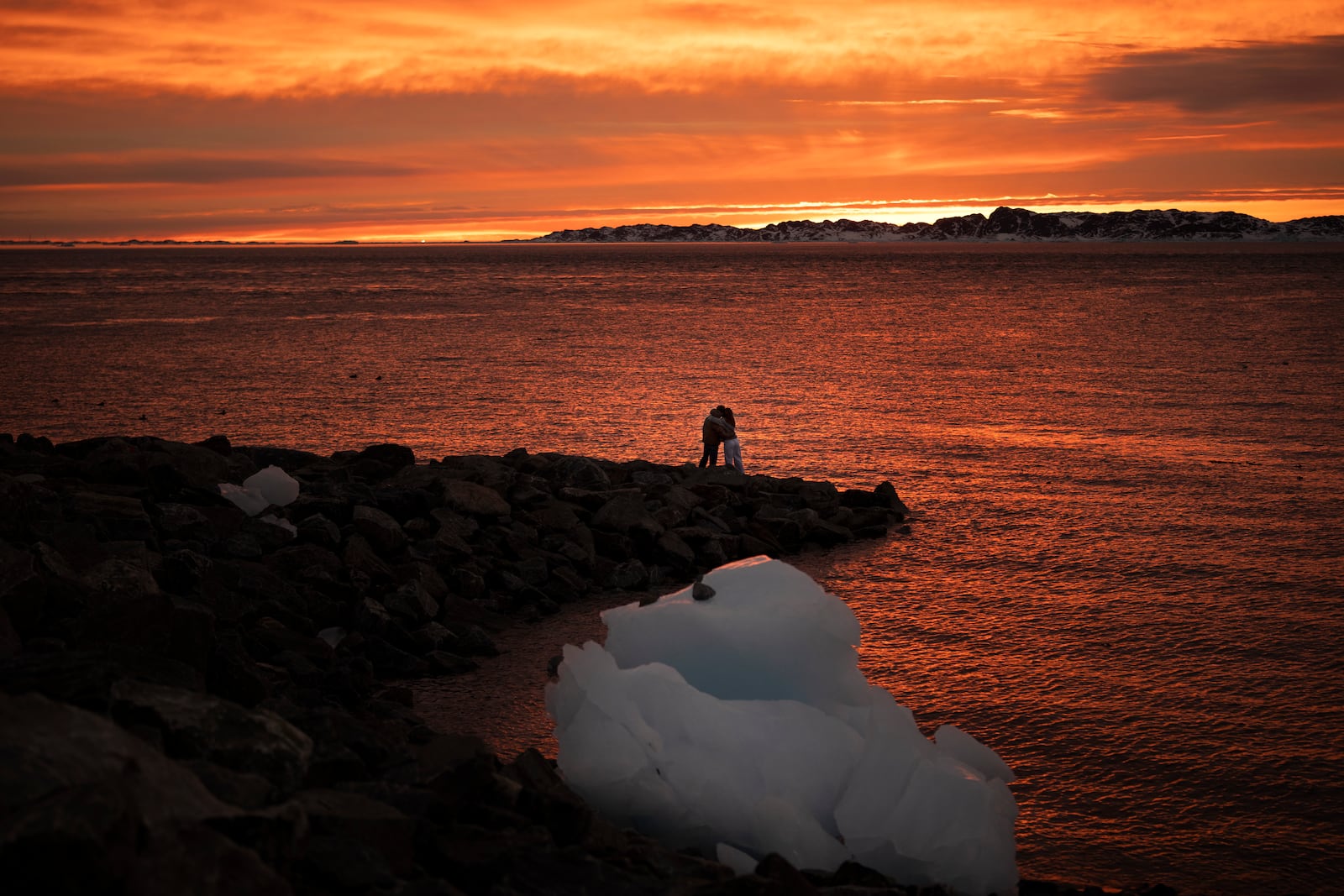 Ana, 18, and Victor, 19, embrace as they watch the sunset in Nuuk, Greenland, Sunday, Feb. 16, 2025. (AP Photo/Emilio Morenatti)