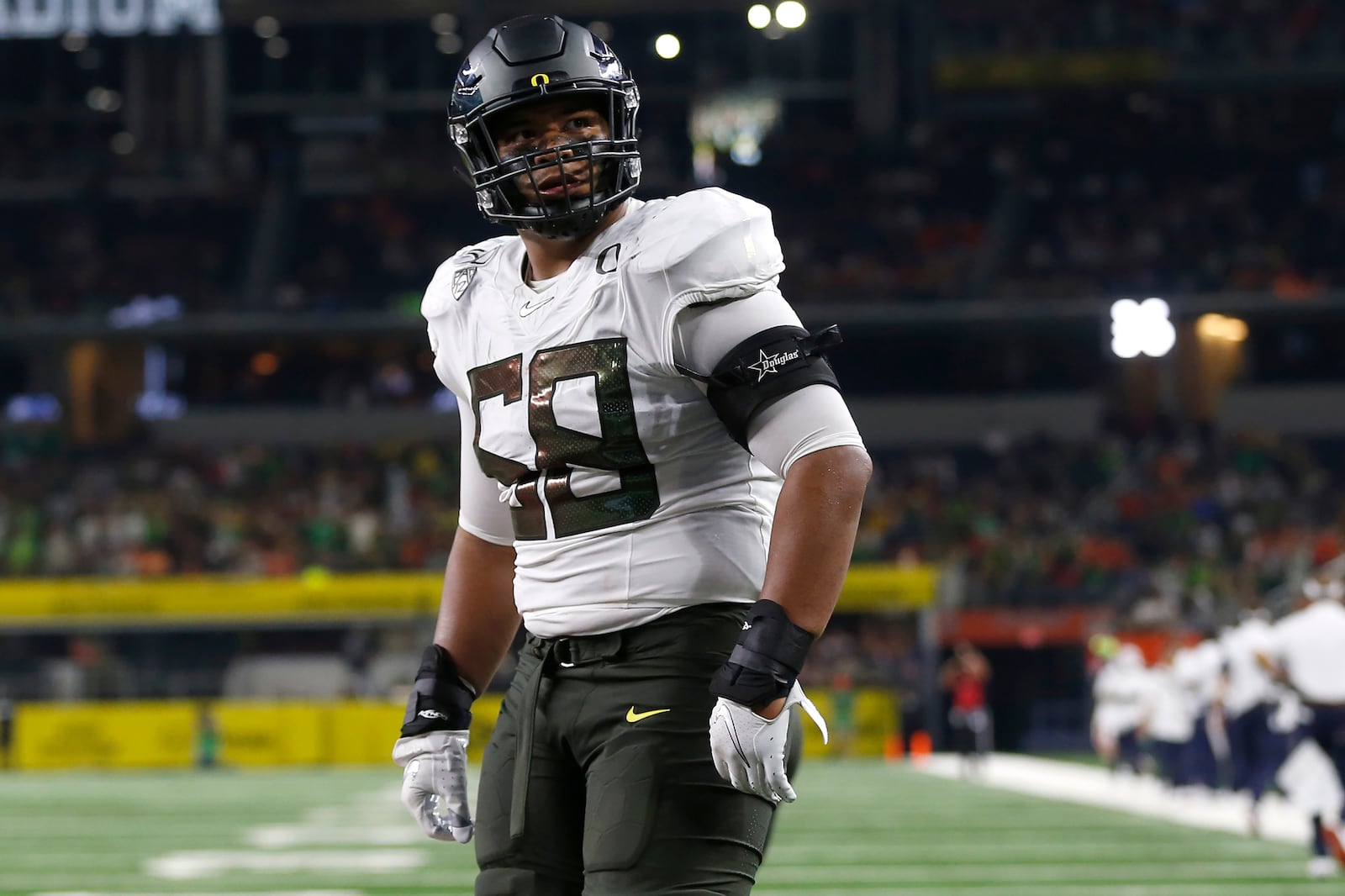 FILE - In this Aug. 31, 2019, file photo, Oregon offensive lineman Penei Sewell (58) looks on as Oregon plays Auburn in an NCAA college football game in Arlington, Texas. The last NFL event not impacted by the COVID-19 pandemic was the 2020 combine in Indianapolis. A year later, with the 2021 combine canceled, the league has released a list of players who would have merited invitations. From such high-profile quarterbacks as Clemson’s Trevor Lawrence and Ohio State’s Justin Fields to guys who sat out last season such as Oregon tackle Penei Sewell, there are 323 players from 100 schools. (AP Photo/Ron Jenkins, File)