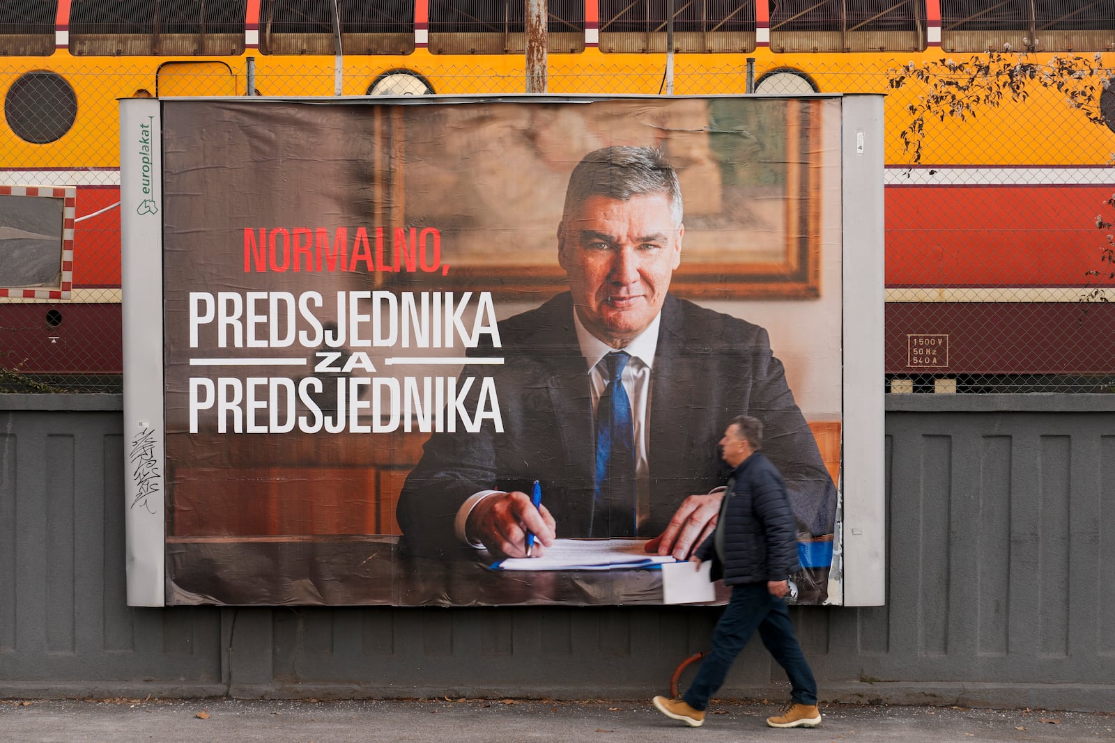 A pedestrian walks past a campaign poster of President incumbent Zoran Milanovic, days ahead of the run-off of the Croatian presidential election, in Zagreb, Croatia, Tuesday, Jan. 7, 2025. (AP Photo/Darko Bandic)