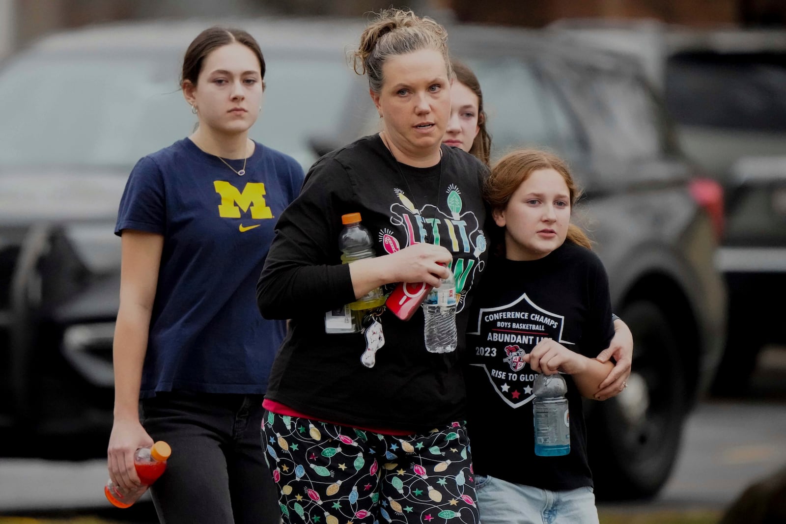 A family leave the shelter after multiple injuries were reported following a shooting at the Abundant Life Christian School, Monday, Dec. 16, 2024. (AP Photo/Morry Gash)