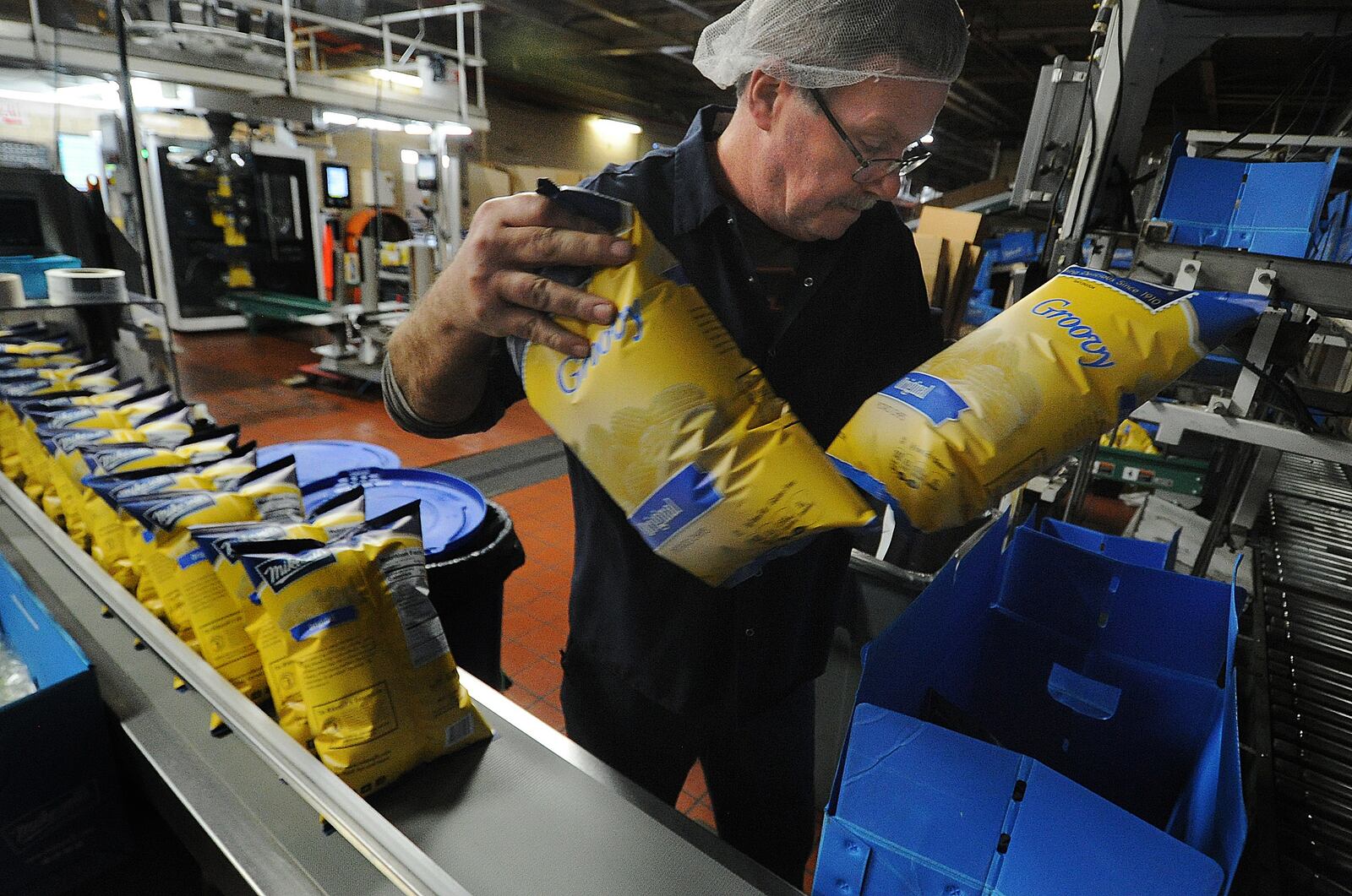 Tim White, a 26 year employee of Mikesell's packs bags of chips into boxes Thursday Dec. 1, 2022. MARSHALL GORBY\STAFF